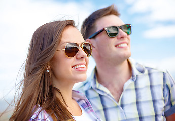 Image showing smiling teenagers in sunglasses having fun outside