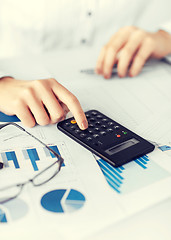 Image showing woman hand with calculator and papers