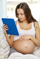 Image showing happy pregnant woman with tablet pc at home