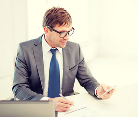 Image showing businessman working with laptop and smartphone