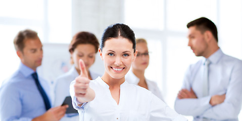 Image showing businesswoman in office showing thumbs up