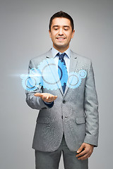 Image showing happy businessman showing virtual projection