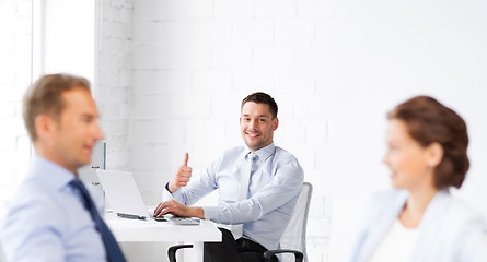 Image showing happy businessman showing thumbs up in office