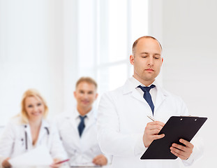 Image showing serious male doctor with clipboard