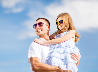 Image showing happy father and child in sunglasses over blue sky