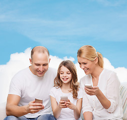 Image showing happy family with smartphones