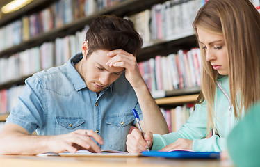 Image showing students writing to notebooks in library