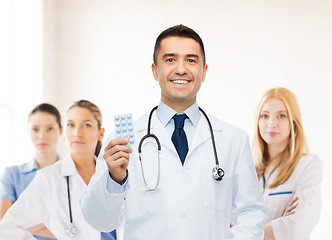 Image showing smiling male doctor in white coat with tablets