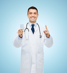 Image showing smiling male doctor in white coat with tablets