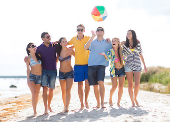 Image showing group of happy friends walking along beach