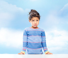 Image showing sad little girl over city background