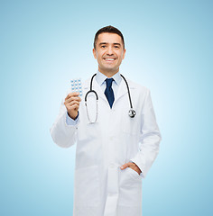 Image showing smiling male doctor in white coat with tablets