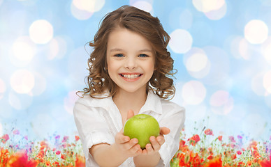 Image showing happy girl holding apple over garden background