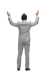 Image showing businessman raising hands up from back