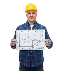 Image showing smiling male builder in helmet with blueprint