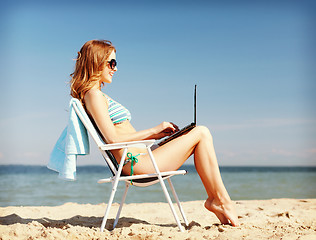 Image showing girl looking at tablet pc on the beach