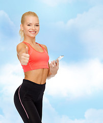 Image showing smiling sporty woman with smartphone