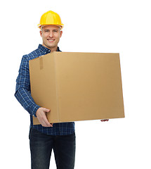 Image showing smiling male builder in helmet with cardboard box