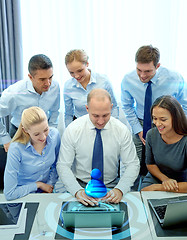 Image showing smiling business people with laptop in office