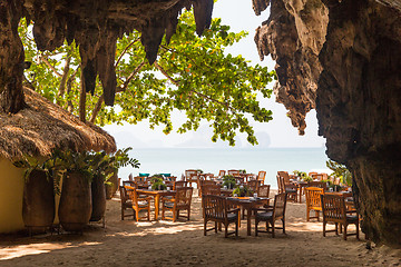 Image showing view to open-air restaurant on beach from cave
