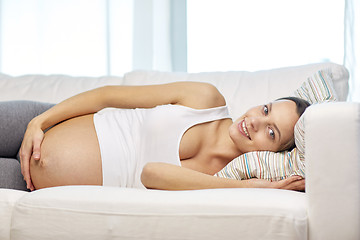 Image showing happy pregnant woman lying on sofa at home