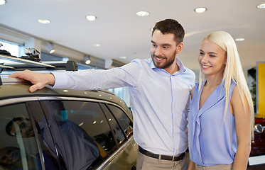 Image showing happy couple buying car in auto show or salon