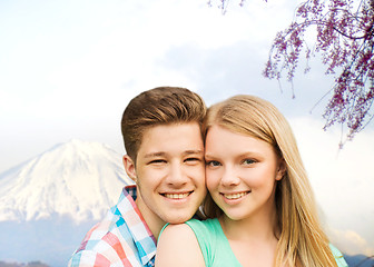 Image showing smiling couple hugging over mountains background