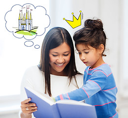 Image showing happy mother and daughter reading fairytale book