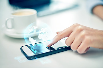 Image showing close up of woman hand with smartphone and globe