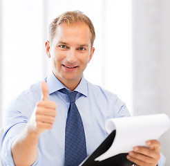 Image showing businessman with papers showing thumbs up