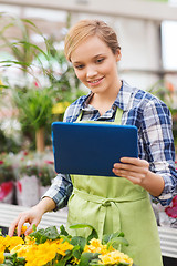 Image showing happy woman with tablet pc in greenhouse