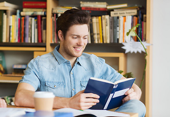 Image showing happy student reading book and drinking coffee