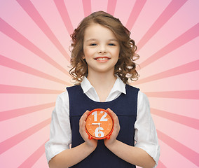 Image showing happy girl with alarm clock over pink background