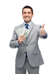 Image showing smiling businessman with money showing thumbs up