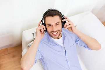 Image showing smiling young man in headphones at home