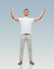 Image showing happy man with raised hands over gray background