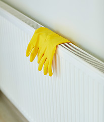 Image showing close up of rubber gloves hanging on heater