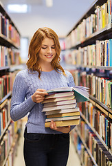 Image showing happy student girl or woman with books in library