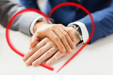 Image showing close up of gay couple hands with wedding rings on