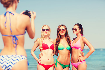 Image showing group of smiling women photographing on beach