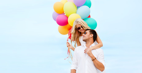 Image showing couple with colorful balloons at seaside