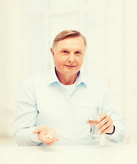 Image showing old man with pills ang glass of water