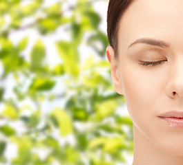 Image showing young woman face over green leaves background