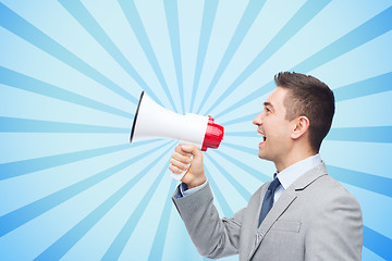 Image showing happy businessman in suit speaking to megaphone