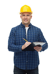 Image showing smiling male builder in helmet with clipboard