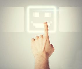 Image showing hand touching virtual screen with smile button