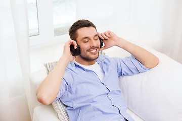 Image showing smiling young man in headphones at home