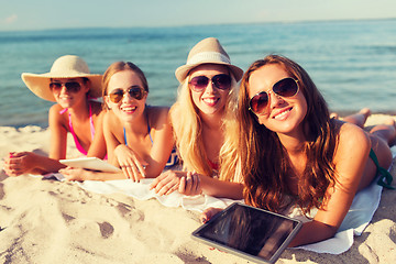 Image showing group of smiling young women with tablets on beach