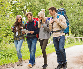 Image showing group of smiling friends with backpacks hiking