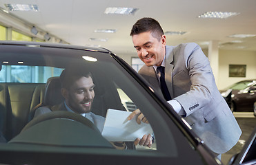 Image showing happy man with car dealer in auto show or salon